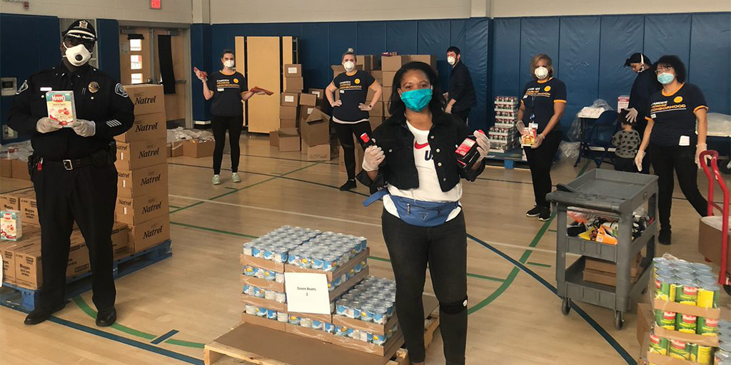 people standing with food|women packing food|young girl in kitchen|