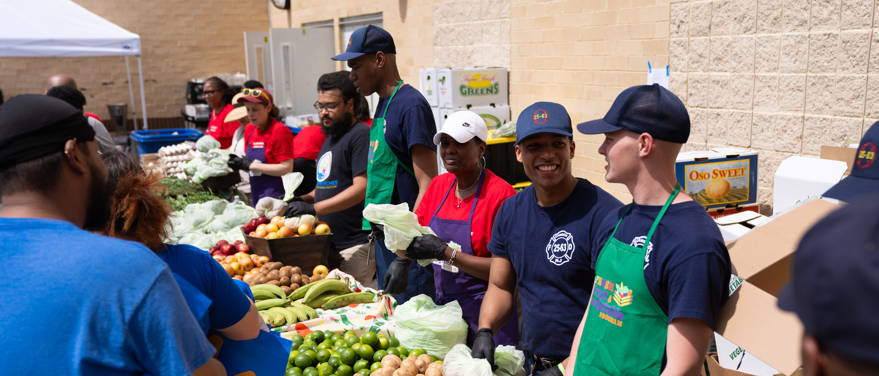 The Campbell's Company Volunteers serve produce at a community farmers market
